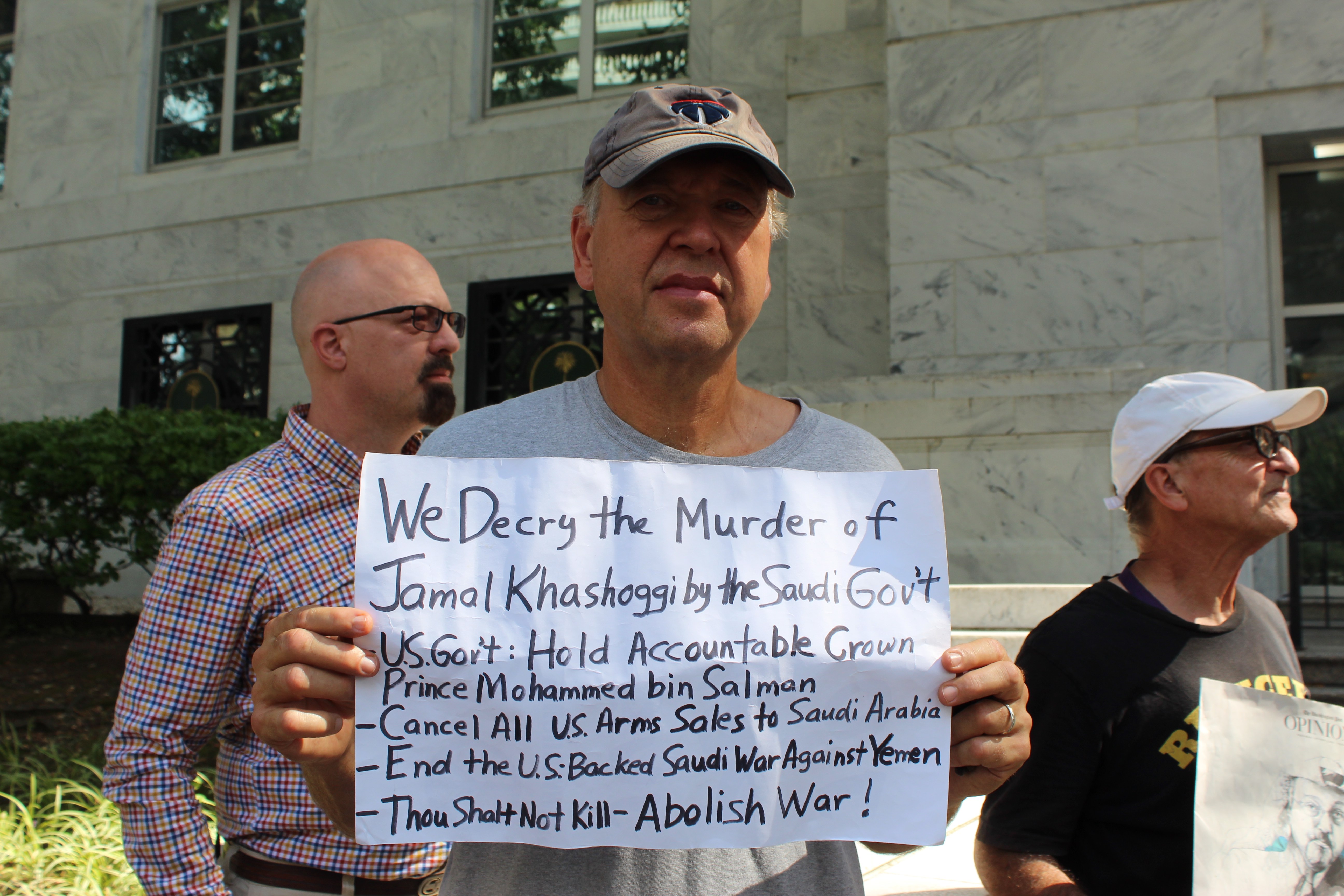 Martin Laffin holds a sign, asking the US government to hold Saudi Arabia accountable for the 2018 murder of Jamal Khashoggi on 2 October 2019 (MEE/Sheren Khalel) 
