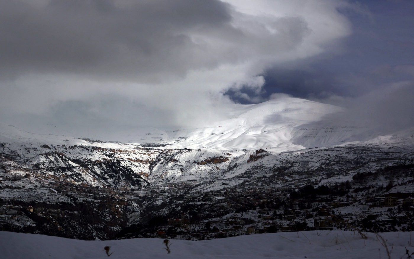 Ville de Bcharré (au premier plan) et du Qurnat as-Sawda, le plus haut sommet du Liban, surplombant la vallée enneigée de la Qadisha (AFP)