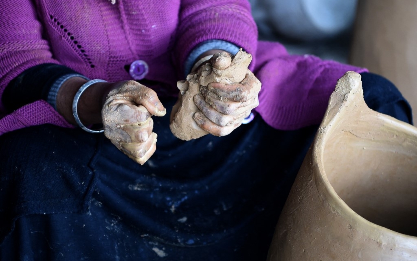 La potière utilise principalement ses mains, mais aussi des ustensiles rustiques, afin de manier la masse d’argile (AFP/Fethi Belaïd)