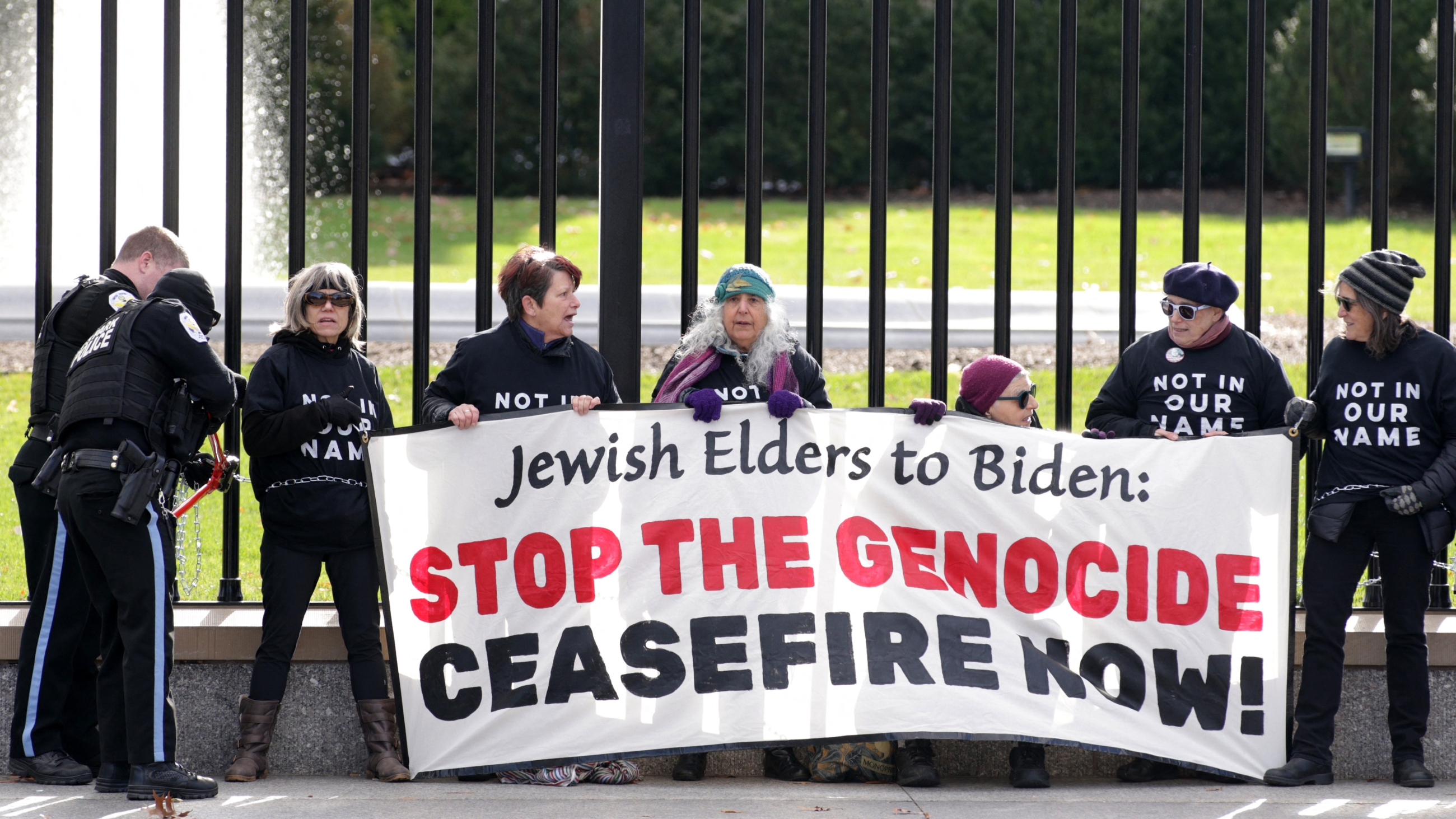 Activists with Jewish Voice for Peace chain themselves to the fence of the White House during a protest calling for an immediate ceasefire in Gaza, in Washington, DC, on 11 December 2023 (Alex Wong/Getty) 