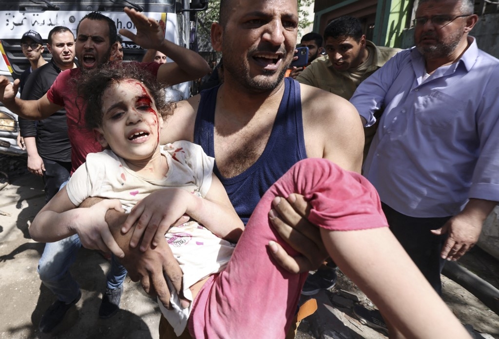 Une jeune fille évacuée des décombres de l’immeuble bombardé ce 16 mai 2021 dans le quartier résidentiel de Rimal à Gaza (AFP) 