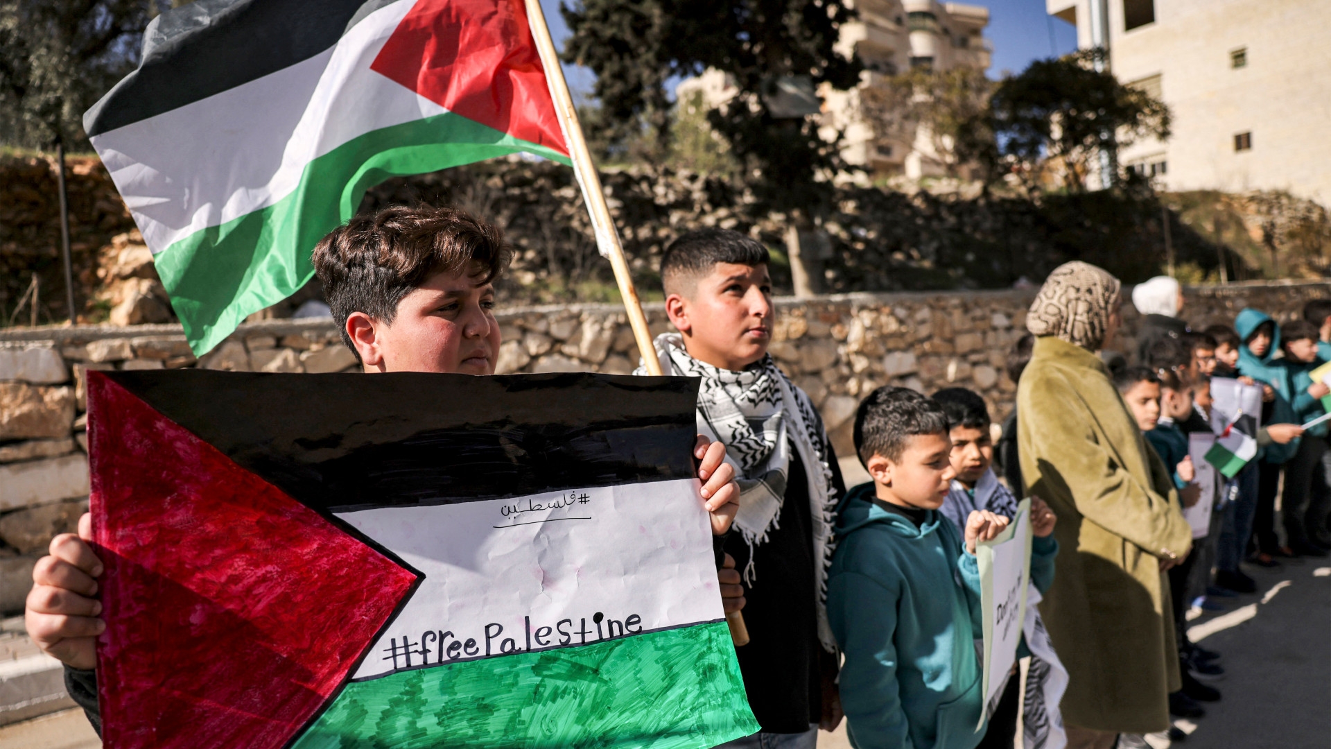 Palestinian students gather for a demonstration outside their school in solidarity with other Palestinians in the Gaza Strip in the city of Hebron in the occupied West Bank on 12 December 2023 (AFP) 