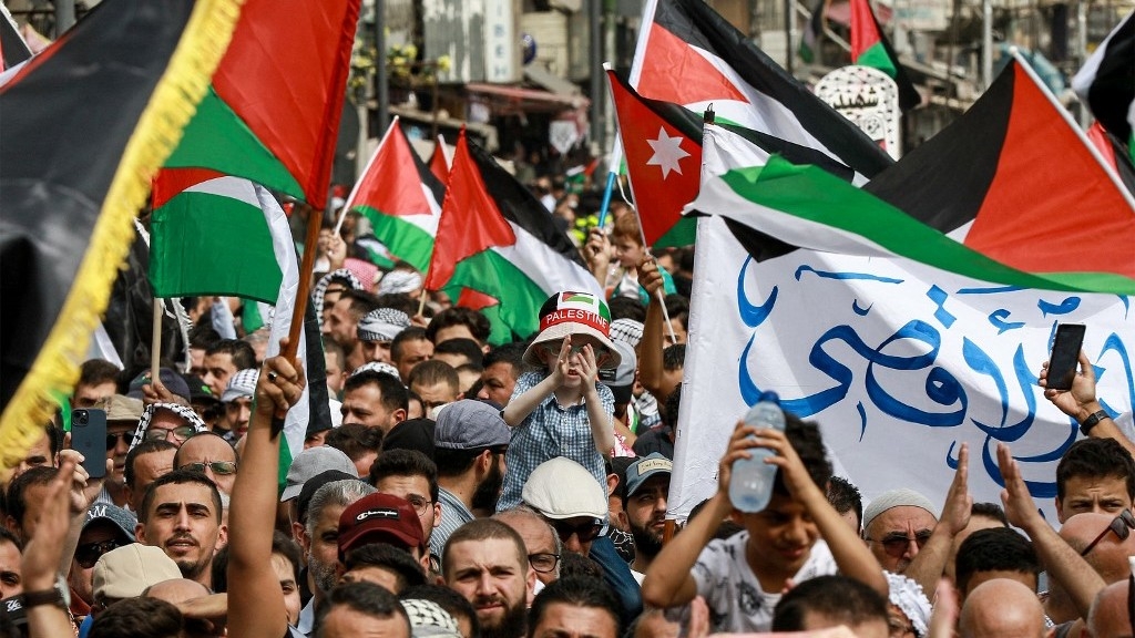 Protesters gather with Jordanian and Palestinian flags in solidarity with Palestinians in Gaza on 27 October in Amman (AFP)
