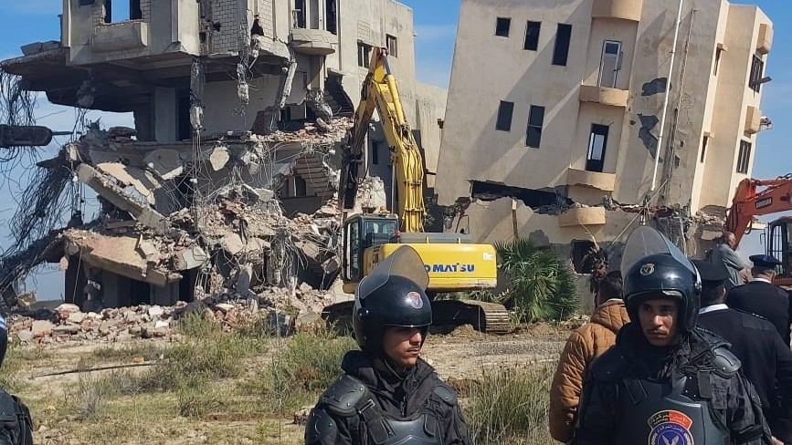 Security forces stand in front of a demolition site in el-Gameel neighbourhood in Port Said, 4 February 2024 (Facebook)