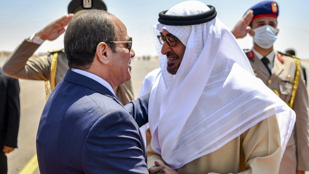This handout image provided by the UAE Ministry Of Presidential Affairs shows (R to L) UAE President Sheikh Mohamed bin Zayed al-Nahyan being received by Egyptian President Abdel Fattah al-Sisi upon arrival in Alamein along Egypt's northern Mediterranean sea coast on 21 August 2022 (AFP)