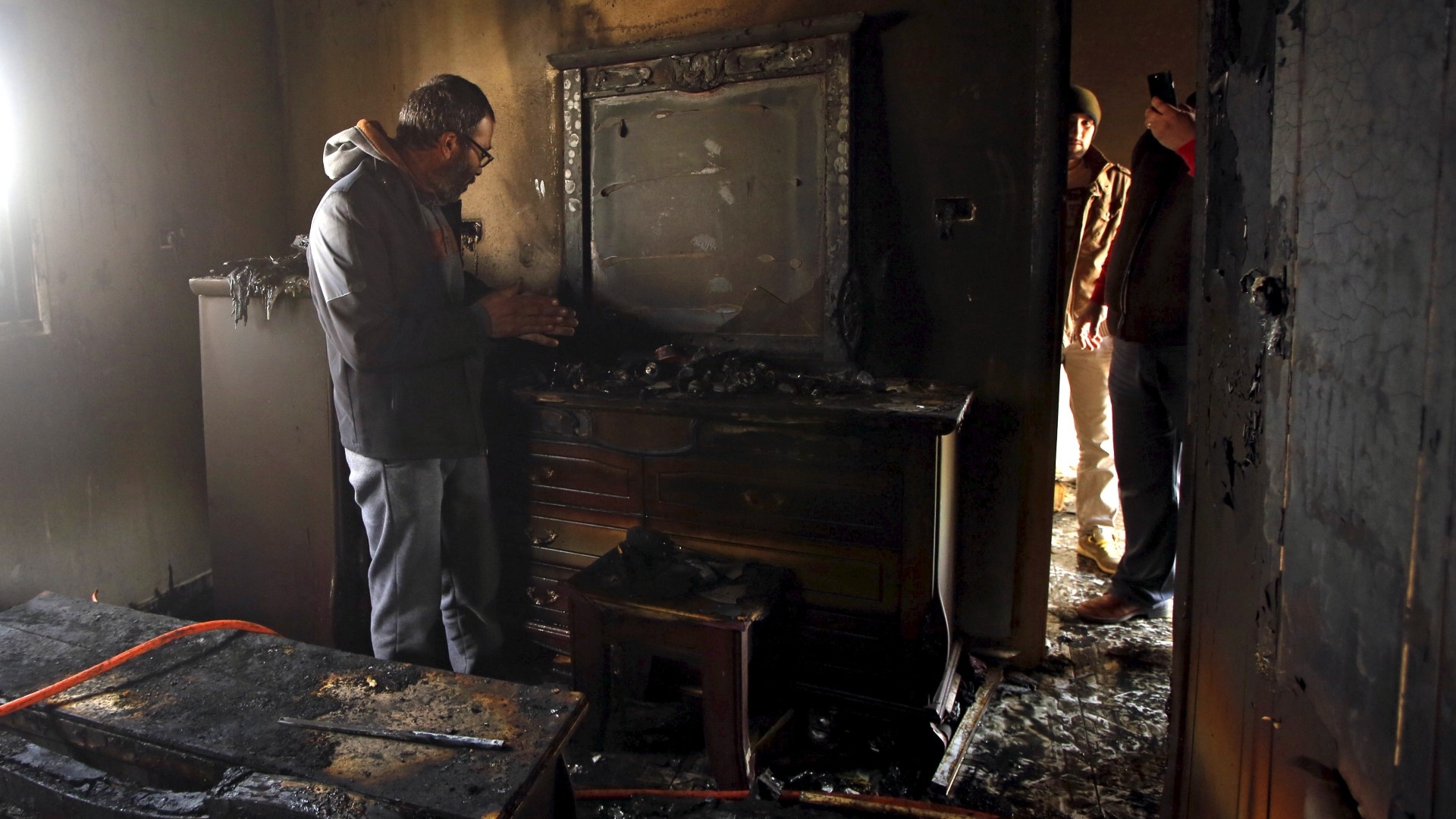 A Palestinian man inspects the damage to the torched house of Ibrahim Dawabsheh, the main witness to an arson attack, in the West Bank village of Duma near Nablus in March 2016