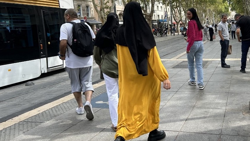 A woman wearing an abaya dress (C) walks in the streets of Marseille, southern France, on 29 August 2023. Abayas - long, flowing dresses of Middle Eastern origin will be banned for schoolgirls, French Education Minister Gabriel Attal announced days before students prepare to return to their classrooms after the summer holidays (AFP)