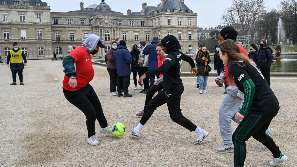 Women play football outside the French Senate in Paris in January 2022 after senators voted to ban the wearing of religious symbols during sports events (AFP)