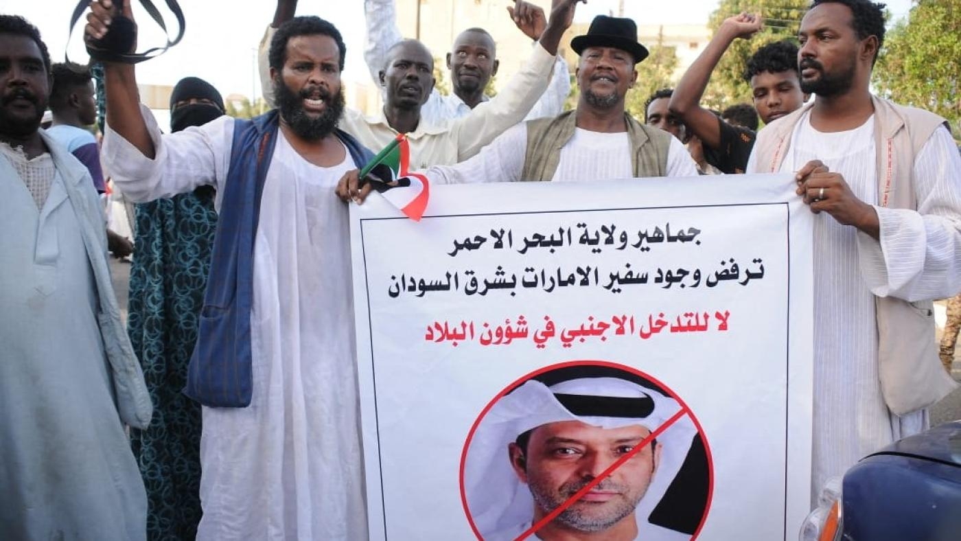 Des partisans de l’armée soudanaise protestent contre l’influence des Émirats arabes unis dans le pays en brandissant une affiche avec un portrait barré de l’ambassadeur émirati, le 20 avril 2023 à Port-Soudan (AFP)