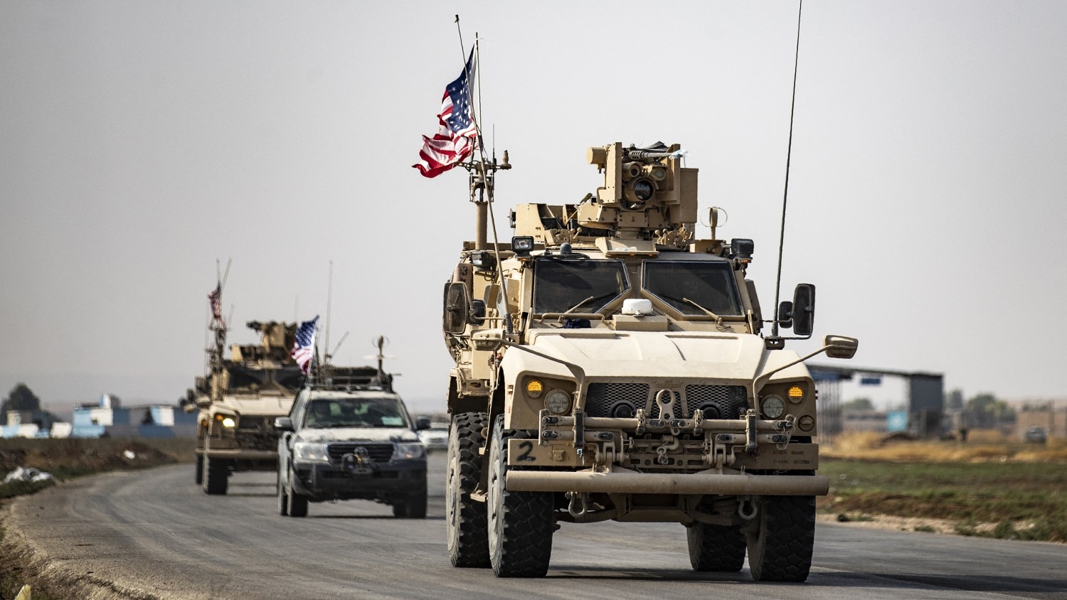 US military vehicles drive on a road after US forces pulled out of their base in the Northern Syrian town of Tal Tamr on 20 October 2019.