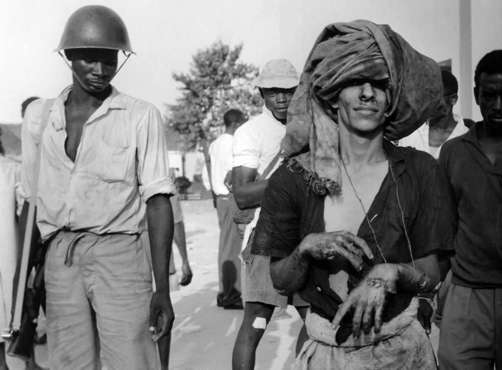 An Arab prisoner led by guards in a camp during the Zanzibar Revolution led by John Gideon Okello, on 12 January 1964. (AFP)
